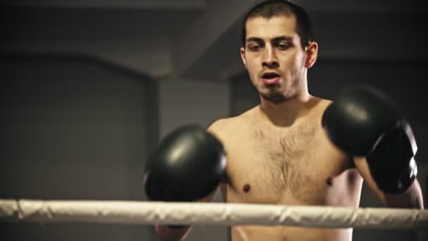 Box training - een vermoeide man spoelt zijn mond en spuugt in de prullenbak - een trainer helpt hem — Stockvideo