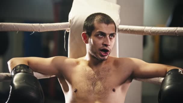 Box training - een man bokser zittend op de stoel in de hoek van de ring - opstaan en naar voren lopen — Stockvideo