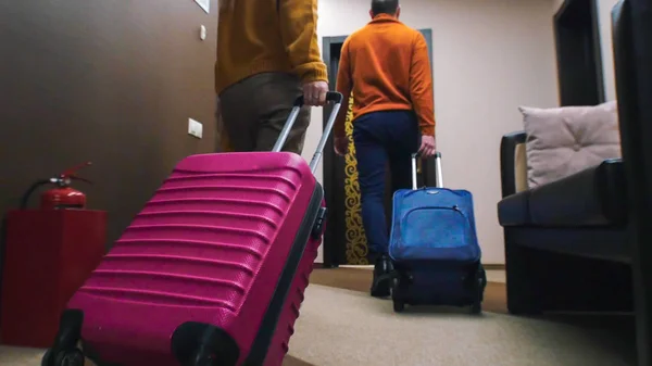 Молодая семья входит в гостиничный номер - тащит за собой багаж — стоковое фото