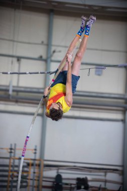 Direğin içinde bir adam barın üzerinden atlıyor.