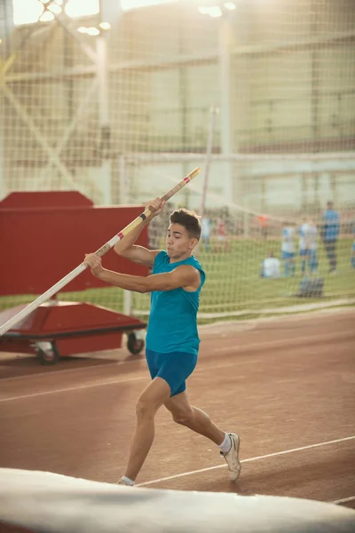 Entrenamiento de salto de poste - joven en forma hombre a punto de saltar —  Fotos de Stock