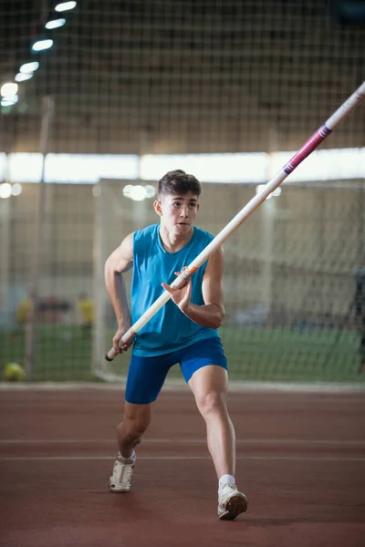 Allenamento a volta polare nello stadio sportivo - giovane che corre in pista con in mano una pole — Foto Stock