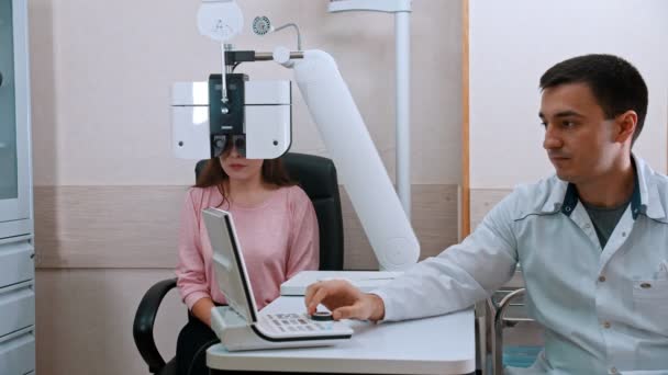 Okulista - młoda kobieta odwiedzająca lekarza dziecięcego w klinice okulistycznej — Wideo stockowe