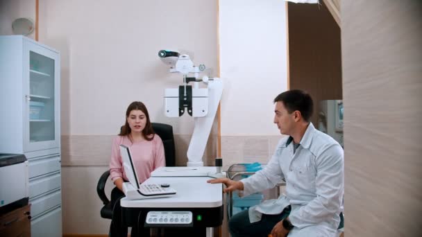 Ophthalmologist - young woman is teling the doctor about her symptoms — Stock Video