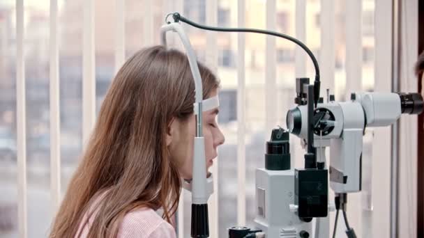 Ophtalmologiste - femme met menton sur dispositif de test de vision moderne — Video