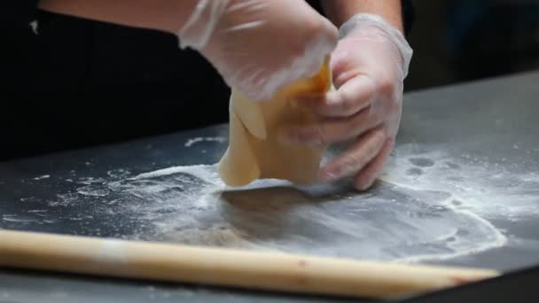 Кухня - человек, который делает тесто - переворачивает его и сглаживает руками — стоковое видео