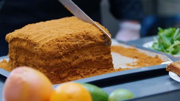 一个人用刀切自制蜂蜜蛋糕的人 — 图库视频影像