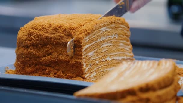 Keuken - een man snijden zelfgemaakte honingcake met een mes en serveer het op de plaat — Stockvideo