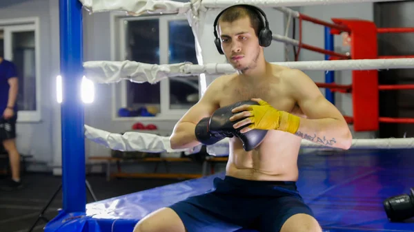 Box - bokser zet zwarte handschoenen op zijn hand — Stockfoto