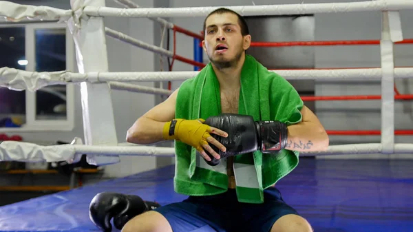 Yeşil havlusu olan boksör eldivenini elinden çıkartıyor. — Stok fotoğraf