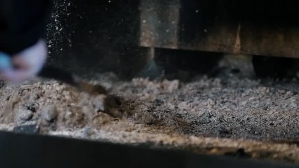 En man städar upp en ugn ur askan efter matlagning — Stockvideo