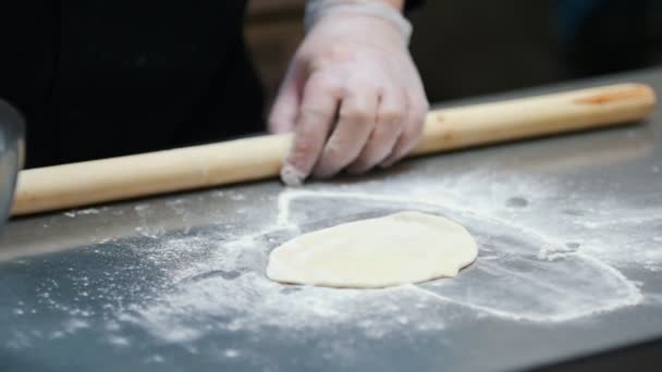 Cuisine - un homme fait une pâte - un chef aplatit la pâte avec un rouleau à pâtisserie — Video