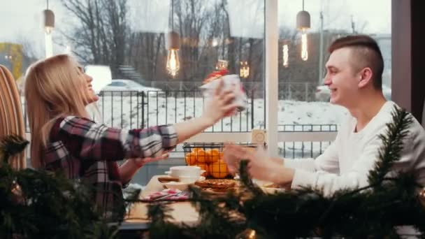 Een schattig stel dat luncht - een vrouw geeft haar vriend een cadeau - hij kust haar in de wang — Stockvideo