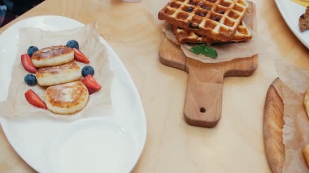 Gofres y otros alimentos en la mesa en la cafetería — Vídeos de Stock