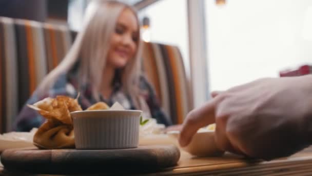 Un par en la cafetería comienzan a comer su comida — Vídeos de Stock