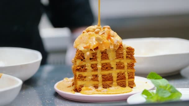 Cocina - Verter una salsa dulce en la parte superior de la torta de miel — Vídeo de stock