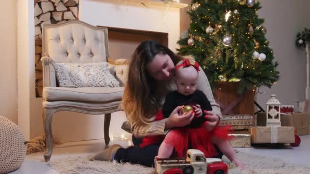一个年轻的女人和她的小宝宝在装饰过的圣诞工作室玩耍 — 图库视频影像