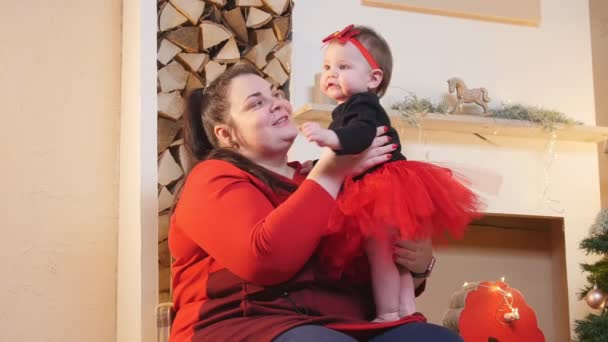 Christmas concept - A plump woman playing with her little baby daughter — Stock Video