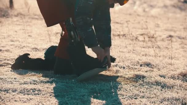 Snowboarden - Een man met een kunstbeen die op het bord staat en er laarzen op zet — Stockvideo