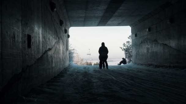 Snowboarden - mensen schaatsen de berg af vanuit de tunnel — Stockvideo