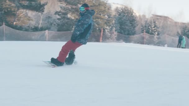 Зимний сноуборд - Человек с современной протезной ногой спускается с заснеженной горы — стоковое видео