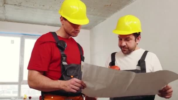 Proyecto de apartamento - hombres trabajadores discutiendo el plan de explotación — Vídeo de stock