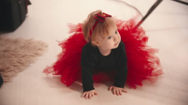 Concepto de Navidad: una niña pequeña arrastrándose por el suelo en el estudio — Vídeo de stock