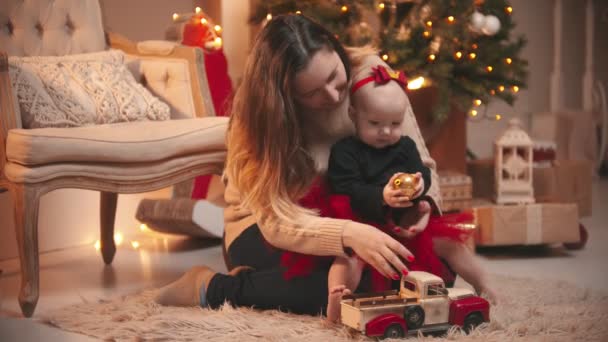 Navidad - Una mujer jugando con su pequeña hija con una bola de Navidad — Vídeos de Stock