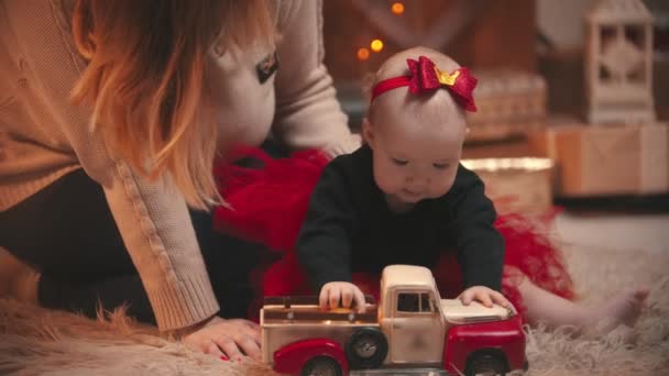 Χριστουγεννιάτικο στούντιο - ένα κοριτσάκι που παίζει με ένα αυτοκινητάκι — Αρχείο Βίντεο