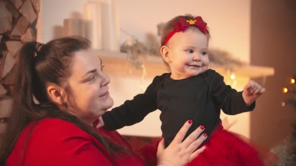 Concepto de Navidad - Una mujer sonriente regordeta sosteniendo a su pequeña hija — Vídeos de Stock