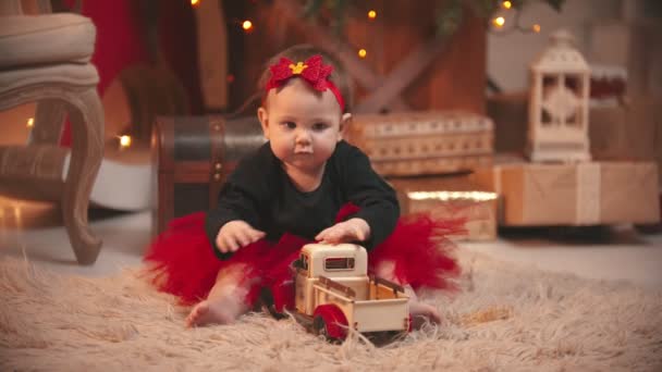 Estúdio de Natal - um pouco bonito bebê menina brincando com um carro de brinquedo — Vídeo de Stock