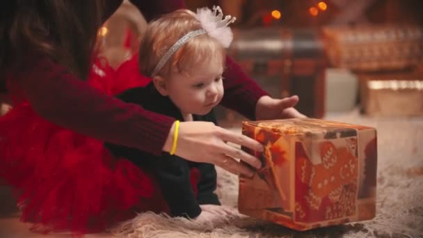 Koncepcja Bożego Narodzenia - słodkie dziecko bawiące się pudełkiem prezentów — Wideo stockowe
