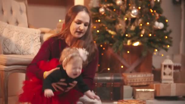 Christmas concept - a woman sitting with her little daughter and playing in the studio — Stock Video