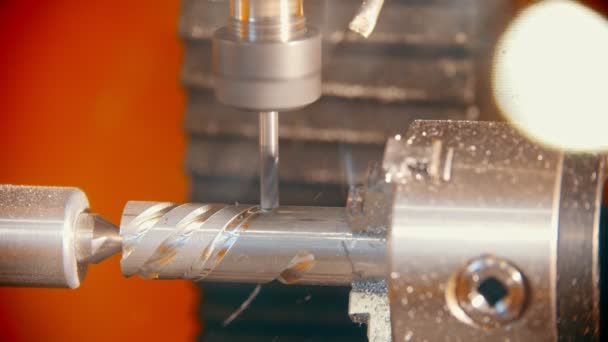Een industriële machine die schroefinkepingen op een ijzeren detail maakt — Stockvideo