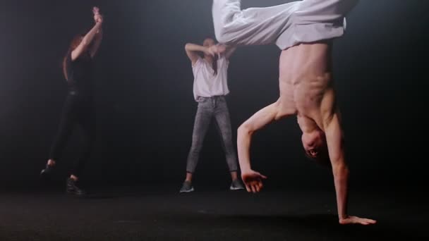 Ομάδα ανθρώπων που χορεύουν σε εσωτερικούς χώρους - ένας άνθρωπος που χορεύει breakdance — Αρχείο Βίντεο