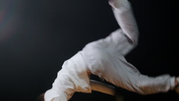 Young fit man break dancer in white clothes spinning aroung on one hand and keeping the balance — 비디오