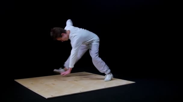 Joven en forma hombre break bailarina en ropa blanca spinning arjalá por una mano — Vídeo de stock