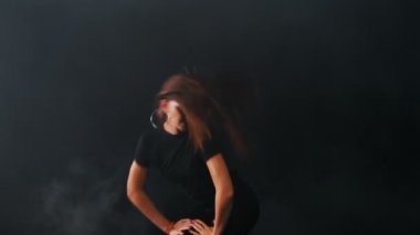 Young attractive woman dancing in dark studio