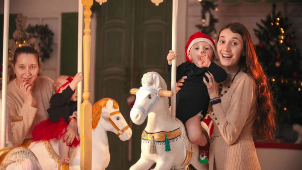 Divertirse con la decoración de Navidad - dos madres con sus bebés — Foto de Stock