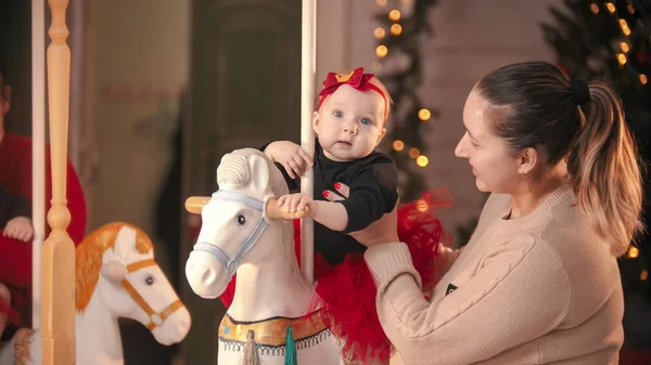 Concepto de Navidad - sonriente madre regordeta en jersey beige con su bebé en el estudio de Navidad — Foto de Stock