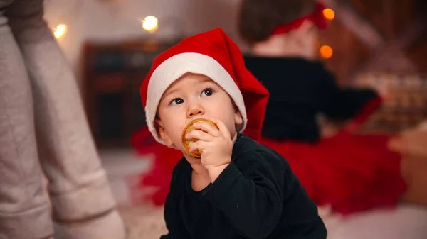 クリスマスの概念-小さな赤ちゃんの男の子彼の口の中にクリスマスボールを入れて — ストック写真