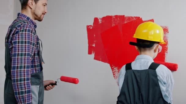 Apartment renovation - family painting walls in red color — ストック動画