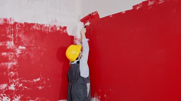 Ein kleiner Junge und sein Vater malen Wände - Vater hilft seinem Sohn, obere Wand zu streichen — Stockvideo