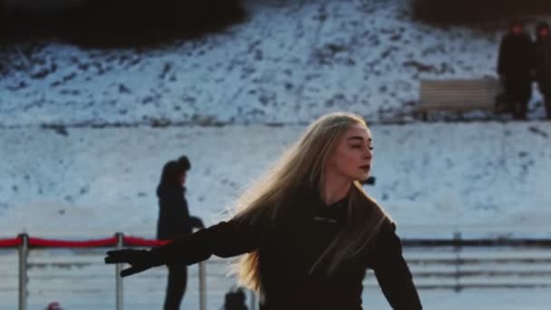 Una joven rubia patinadora artística en pista de hielo — Vídeos de Stock