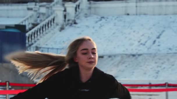 A young woman professional figure skater spinning around herself on ice rink outdoors — 비디오