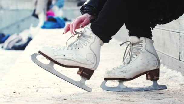 Eine Frau löst ihre Eiskunstlaufschuhe — Stockvideo