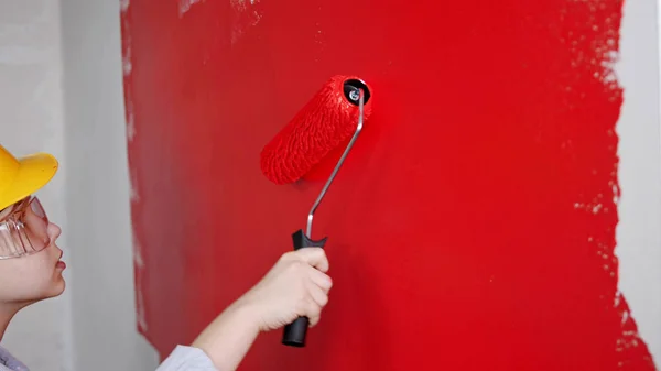 Een kleine jongen schilderen muur met rode verf — Stockfoto