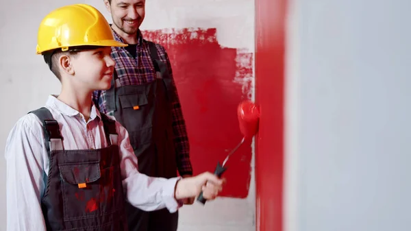 Reparatie ontwerp appartement - kleine jongen en zijn vader schilderen muren in de kamer — Stockfoto