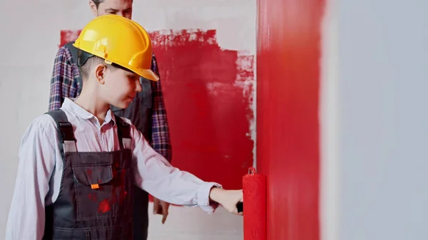 Réparation appartement brouillon - petit garçon et son père mur de peinture en couleur rouge — Photo