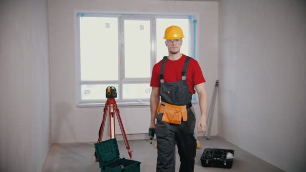 A young man worker in draft apartment holding instrument — Stock Video